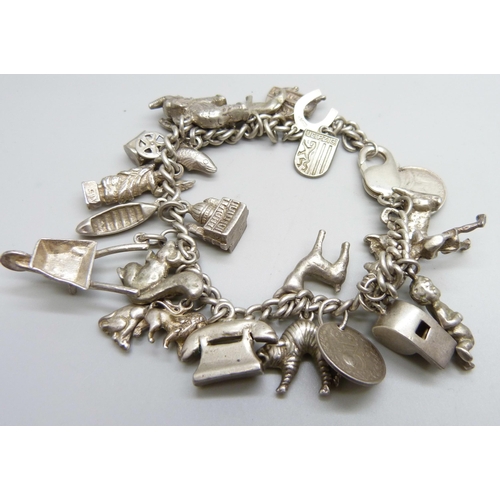 1068 - A silver charm bracelet, with approximately 26 silver and white metal charms, 94.1g