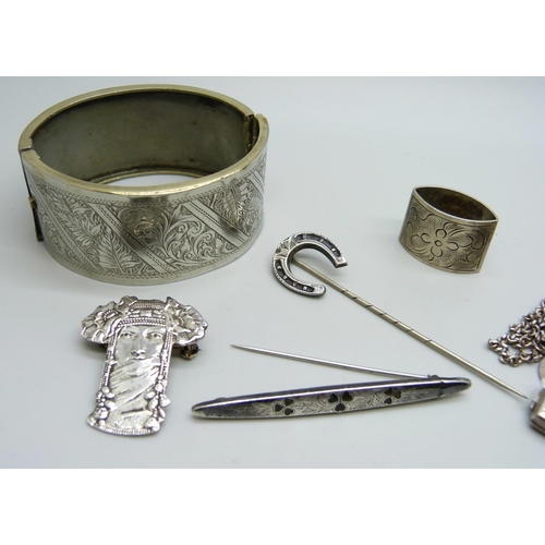 1098 - A hallmarked silver shamrock brooch, a bangle, three lockets, a cross pendant, etc.