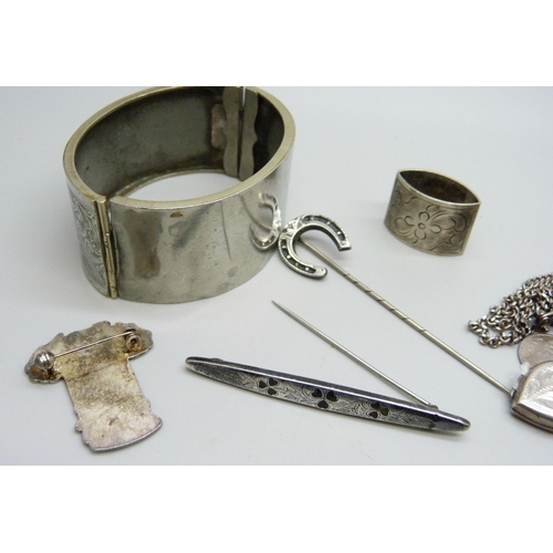 1098 - A hallmarked silver shamrock brooch, a bangle, three lockets, a cross pendant, etc.