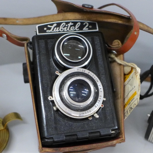 616 - A Swiss 1950s Swiza alarm clock, three cameras including Lubitel 2