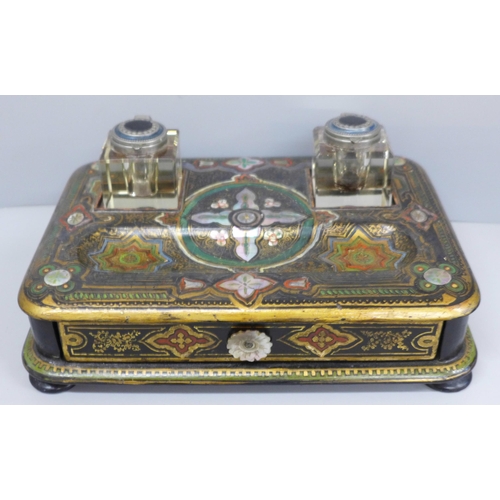 637 - A paper mache pen stand with a pair of ink bottles, painted and inlaid with mother of pearl, 27cm