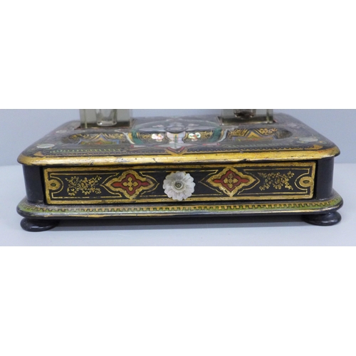 637 - A paper mache pen stand with a pair of ink bottles, painted and inlaid with mother of pearl, 27cm