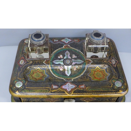 637 - A paper mache pen stand with a pair of ink bottles, painted and inlaid with mother of pearl, 27cm