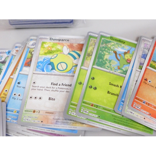 656 - 100 Reverse Holo Pokemon cards, four books and a quantity of empty packs