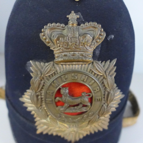 784 - A Hampshire regiment blue cloth helmet, issue mark 1911