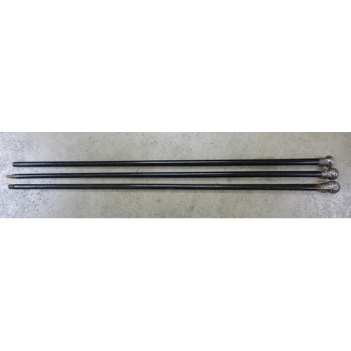 806 - Three silver topped ebonised walking canes with engraved decoration to the tops