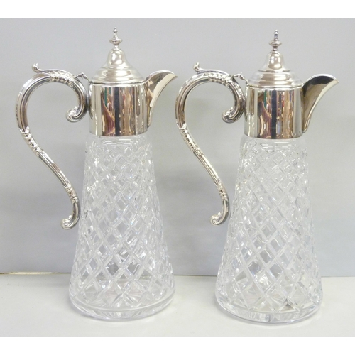 857 - A pair of silver topped glass claret jugs, Birmingham 1989