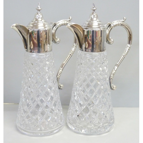 857 - A pair of silver topped glass claret jugs, Birmingham 1989