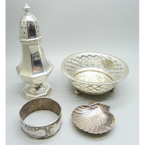 890 - A silver caster, Chester 1908, a pierced silver dish,  a silver napkin ring and a caddy spoon marked... 