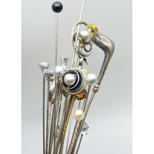 911 - A collection of hat pins, including two hallmarked silver in the form of golf clubs, one by Charles ... 