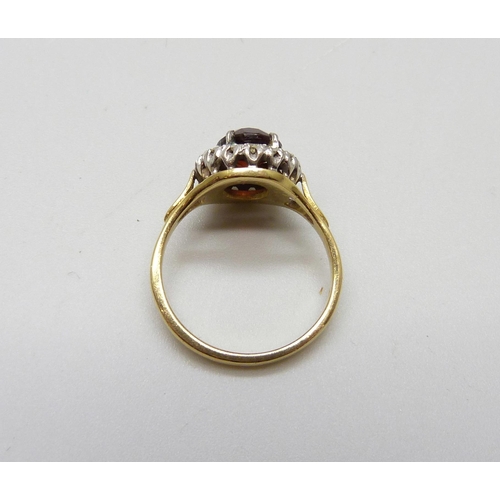 980 - An 18ct gold garnet and diamond halo ring, 4.4g, L