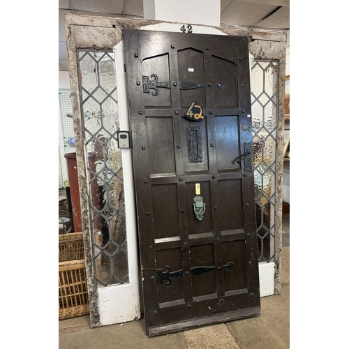 257 - A 1950's oak and iron work door and leaded glass door frame