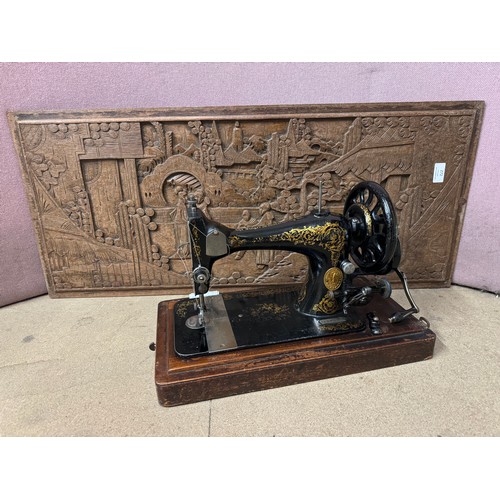 272 - A carved hardwood Oriental plaque and a cased Singer sewing machine