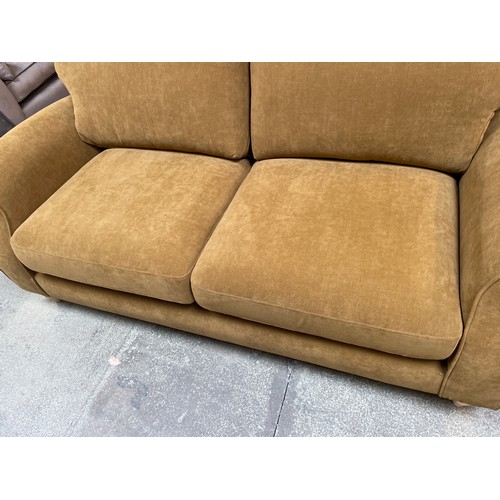 1479 - An Ochre velvet three seater sofa