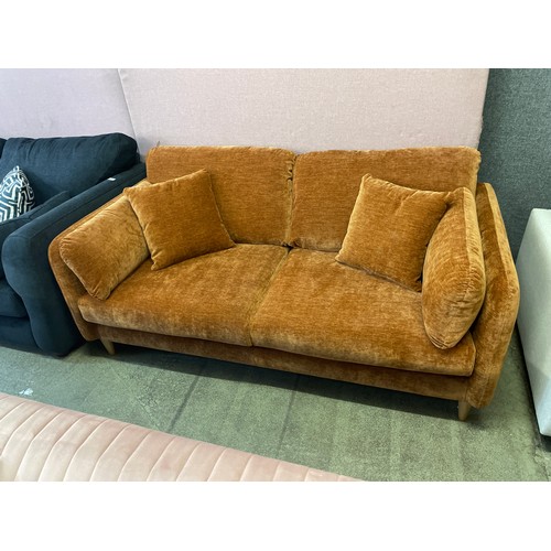 1481 - An ochre velvet three seater sofa