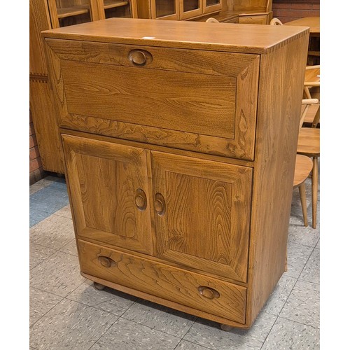 23B - An Ercol Blonde elm Windsor writing cabinet