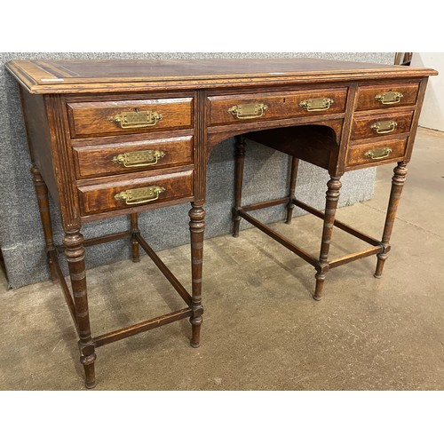 115 - A Victorian Aesthetic Movement oak and red leather topped desk