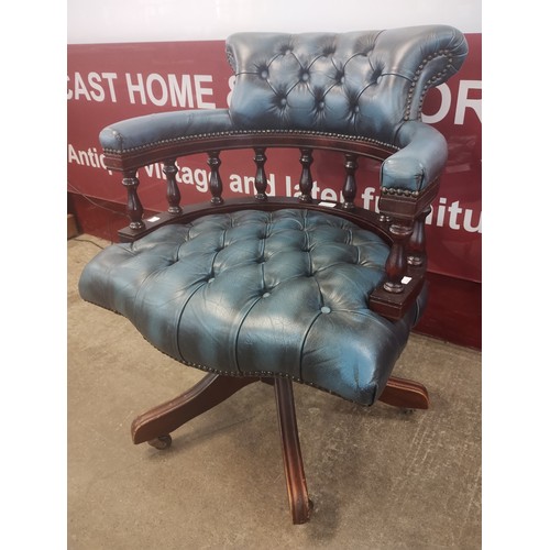 127 - A mahogany and blue leather revolving Captains desk chair