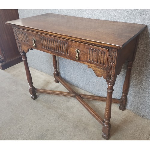 142A - A 17th Century style carved oak single drawer side table