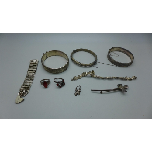 1009 - A collection of silver jewellery including three bangles, two stone set rings, a thistle brooch, etc... 