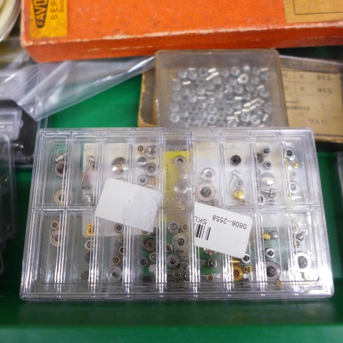 681 - A collection of watch crowns, spring bars, screws, watch hands etc.