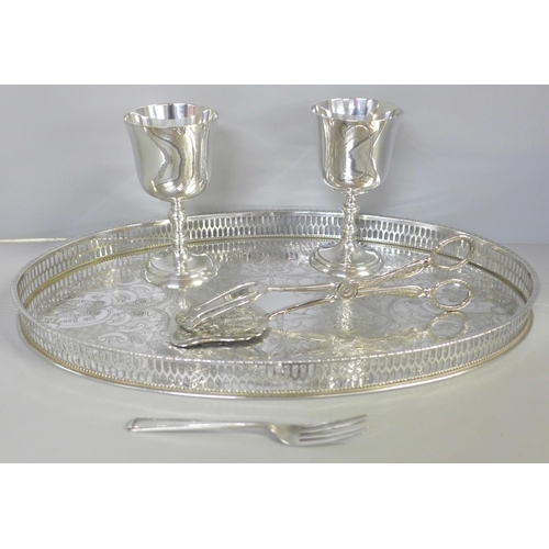 740 - A silver fork, a chased silver plated tray by Viners, a pair of silver plated asparagus tongs and tw... 