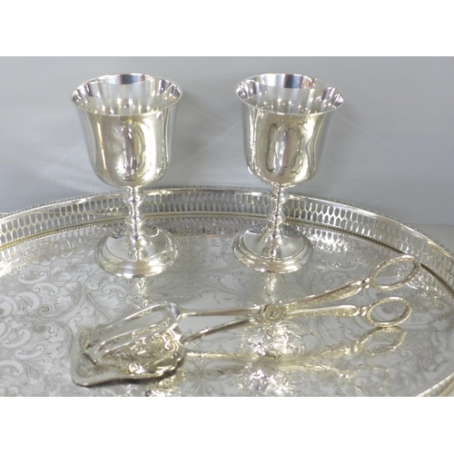 740 - A silver fork, a chased silver plated tray by Viners, a pair of silver plated asparagus tongs and tw... 