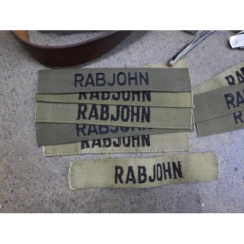 755 - Military uniform belts, uniform badges, name patches 'Rabjohn', lighters, whistles, etc.