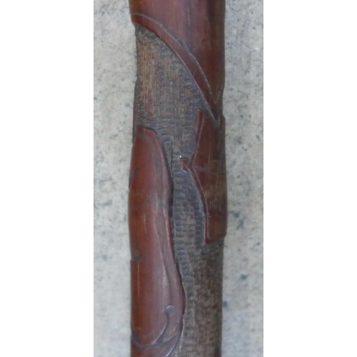 800 - A Japanese carved walking cane and a carved ebony walking stick