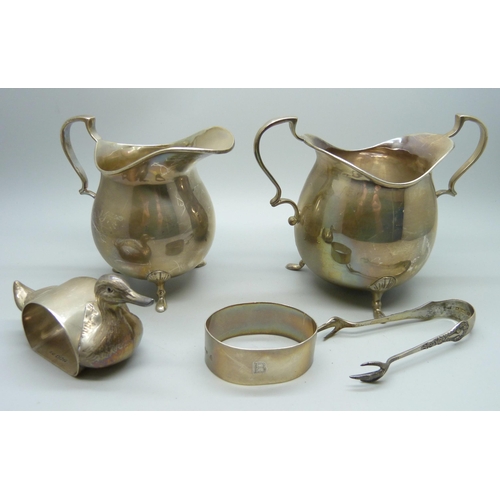 831 - A silver cream jug and sugar, two silver napkin rings, one in the form of a duck and a pair of silve... 