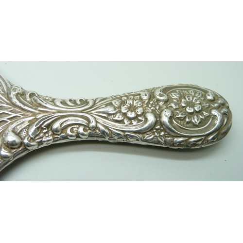 833 - An embossed silver hand mirror, a/f