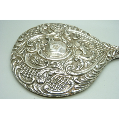 833 - An embossed silver hand mirror, a/f