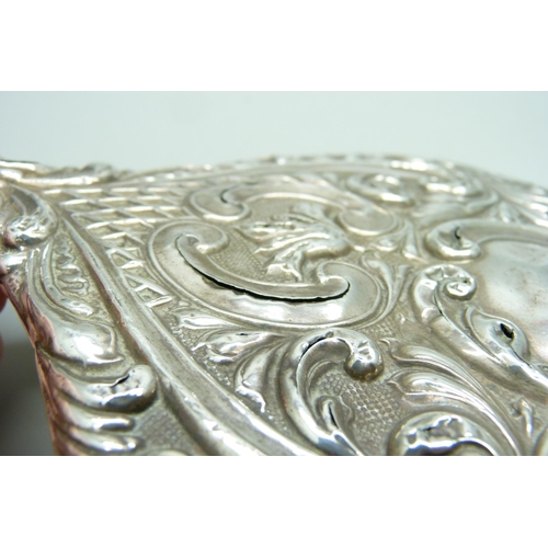 833 - An embossed silver hand mirror, a/f