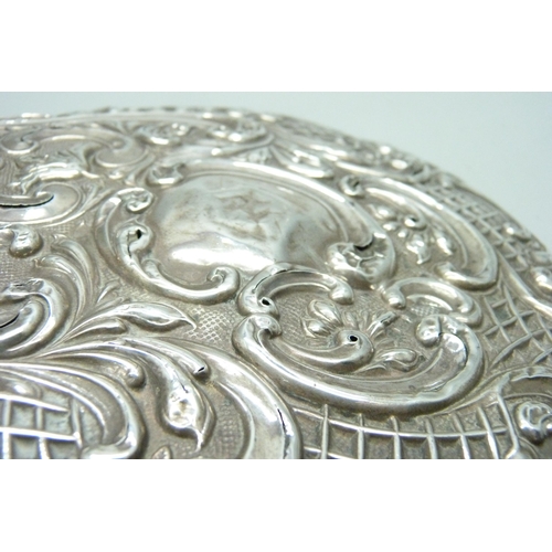 833 - An embossed silver hand mirror, a/f