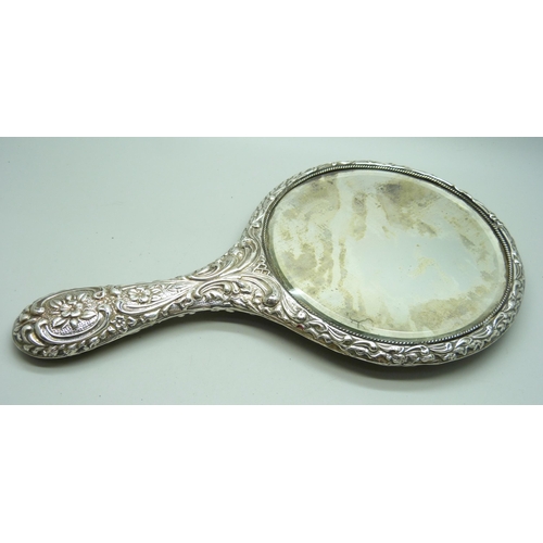 833 - An embossed silver hand mirror, a/f