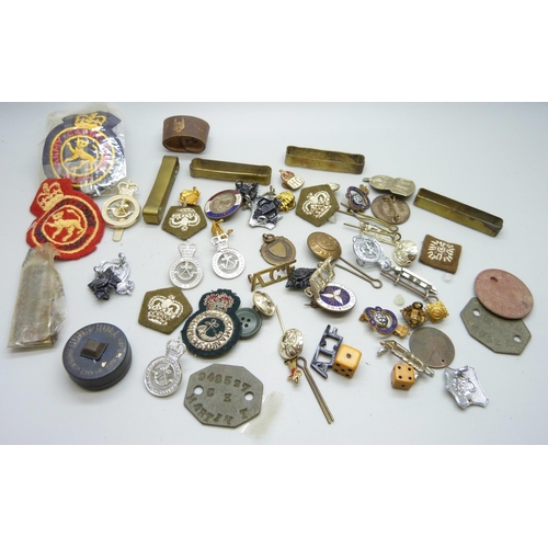 869 - A collection of military badges, dog tags, other badges, etc.