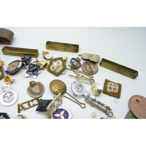 869 - A collection of military badges, dog tags, other badges, etc.