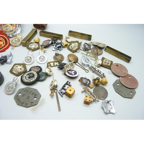 869 - A collection of military badges, dog tags, other badges, etc.