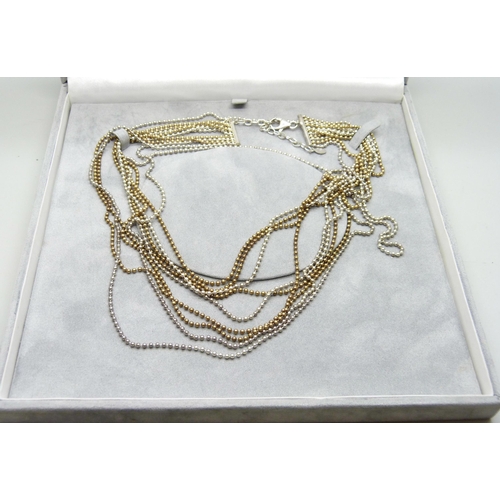 873 - An eleven strand silver and silver gilt necklace, boxed