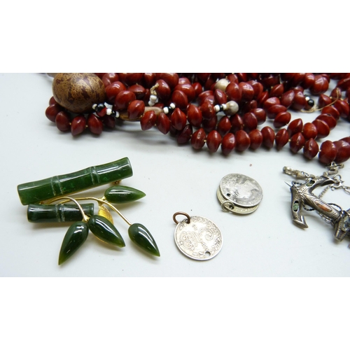 885 - A collection of jewellery including a carved jade brooch, coral necklaces, (requiring fasteners), a ... 