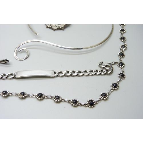 952 - A silver bracelet, 21g, a silver necklace, a silver collar necklace, two brooches and a pendant