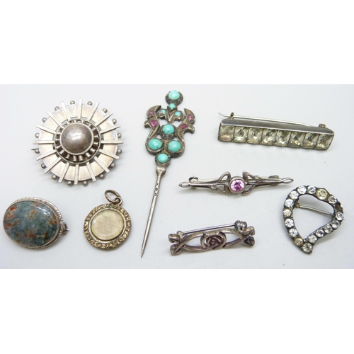 994 - A moss agate brooch, five other brooches, a turquoise and red stone pin and a memorial charm