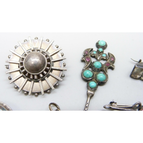 994 - A moss agate brooch, five other brooches, a turquoise and red stone pin and a memorial charm