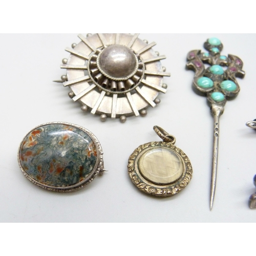 994 - A moss agate brooch, five other brooches, a turquoise and red stone pin and a memorial charm