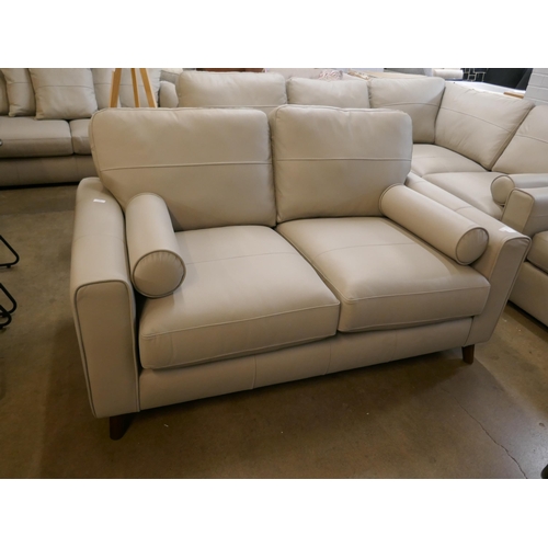 1380 - A stone leather two seater sofa