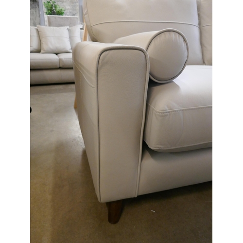 1380 - A stone leather two seater sofa