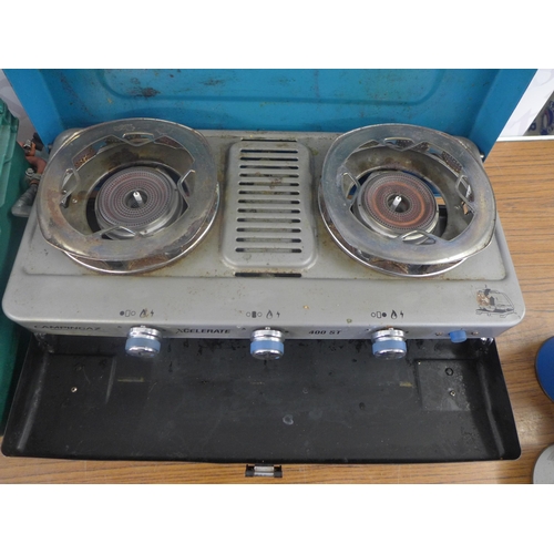 2353 - A Camping Gaz Xcelerate 3 burner camping  cooker with a  1/2 full gas bottle and a plastic crate of ... 