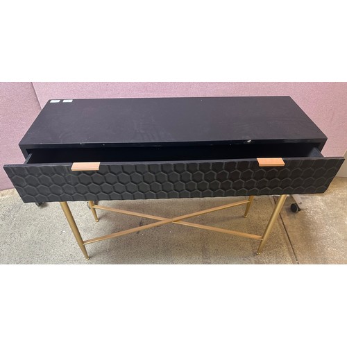 1456A - A black console table with gold legs