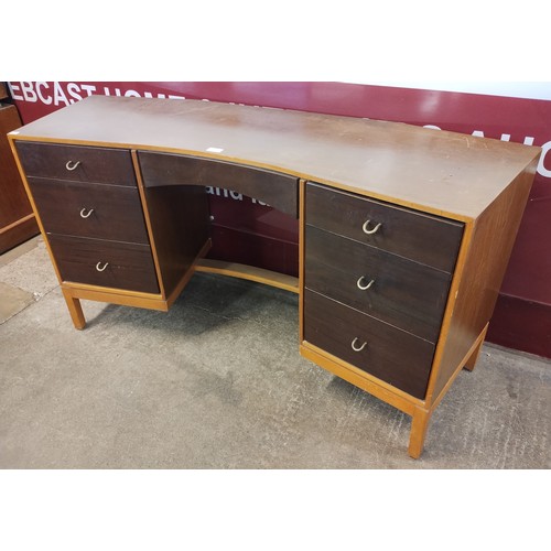 93B - A Stag concave tola wood and teak desk, designed by John and Sylvia Reid