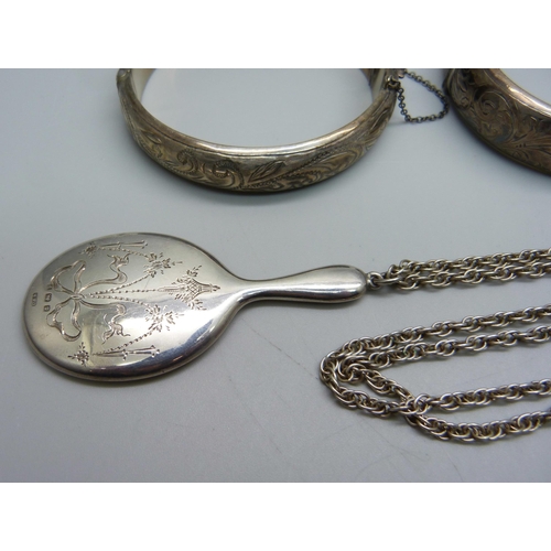 1002 - Two silver bangles (one a/f), a silver chain, a small silver hand mirror pendant, a silver thimble c... 